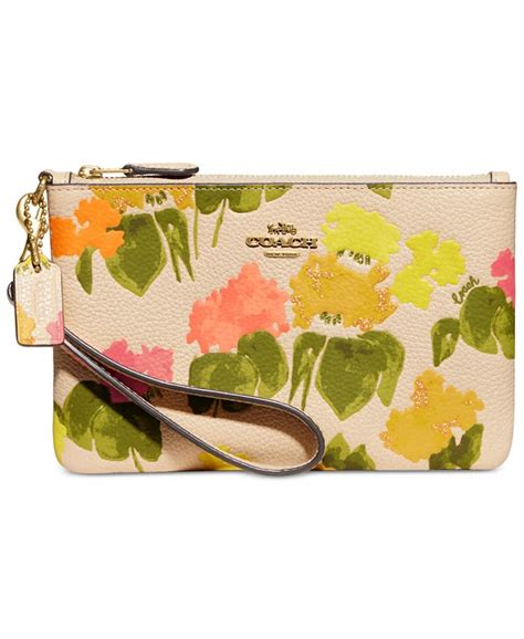 Coach floral wristlet - Crafted of sturdy coated canvas featuring a modern graphic floral print, this wristlet is perfectly sized for cards, cash and a phone. Finished with smooth leather details, wear it on your wrist or clip it inside a larger Coach bag.